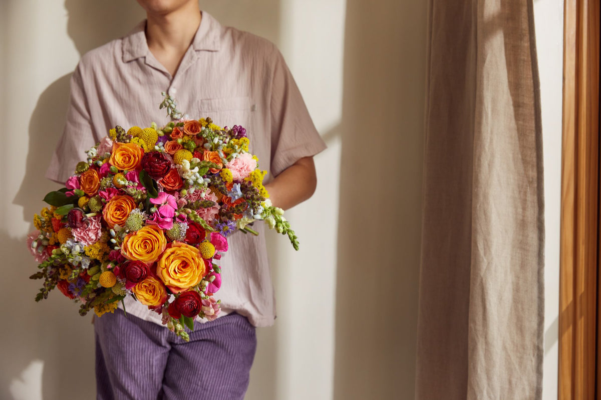 Man holding a summer bouquet.