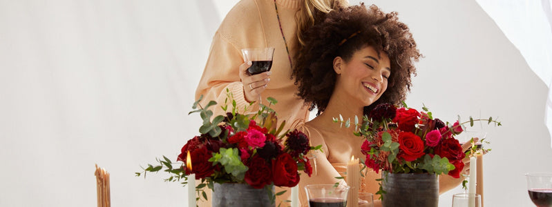 Close up of two women admiring their Valentine's Day flower arrangements.