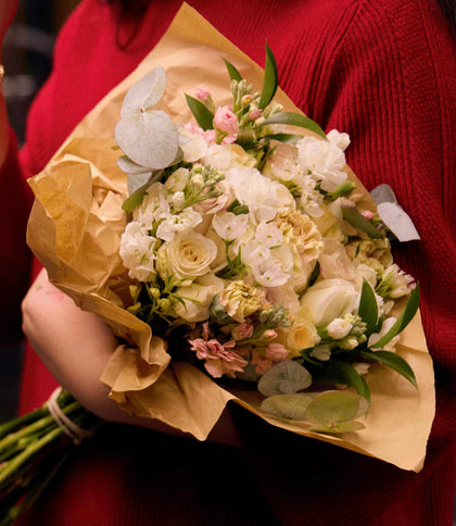 Bouquet of flowers held by a person wearing a red sweater