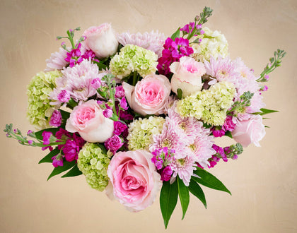 Bouquet of pink and green flowers on a beige background