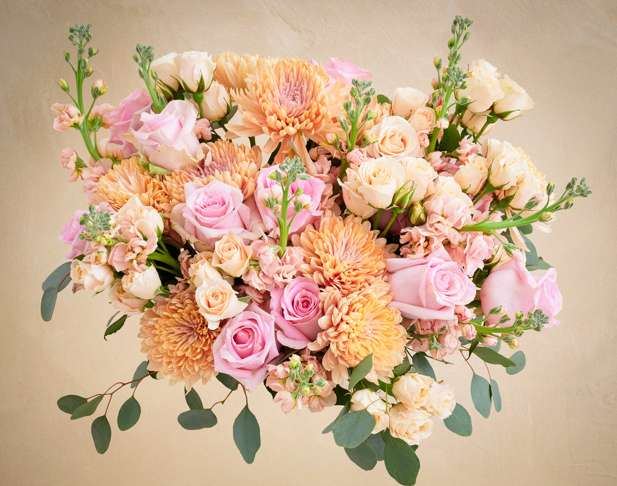 Bouquet of pink, orange, and white flowers on a beige background