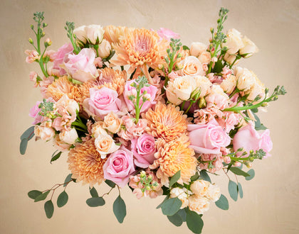Bouquet of pink, orange, and white flowers on a beige background