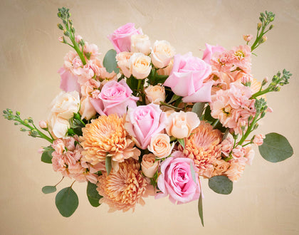 Bouquet of pink and peach flowers on a beige background