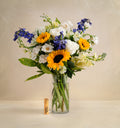 Bouquet of flowers in a clear vase on a beige background