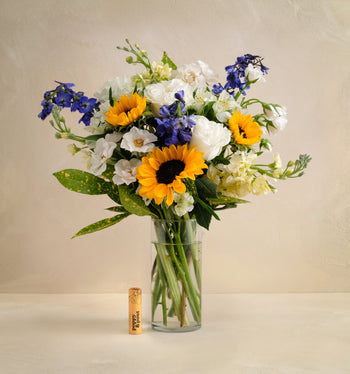 Bouquet of flowers in a clear vase on a beige background