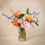 Bouquet of flowers in a clear vase on a beige background