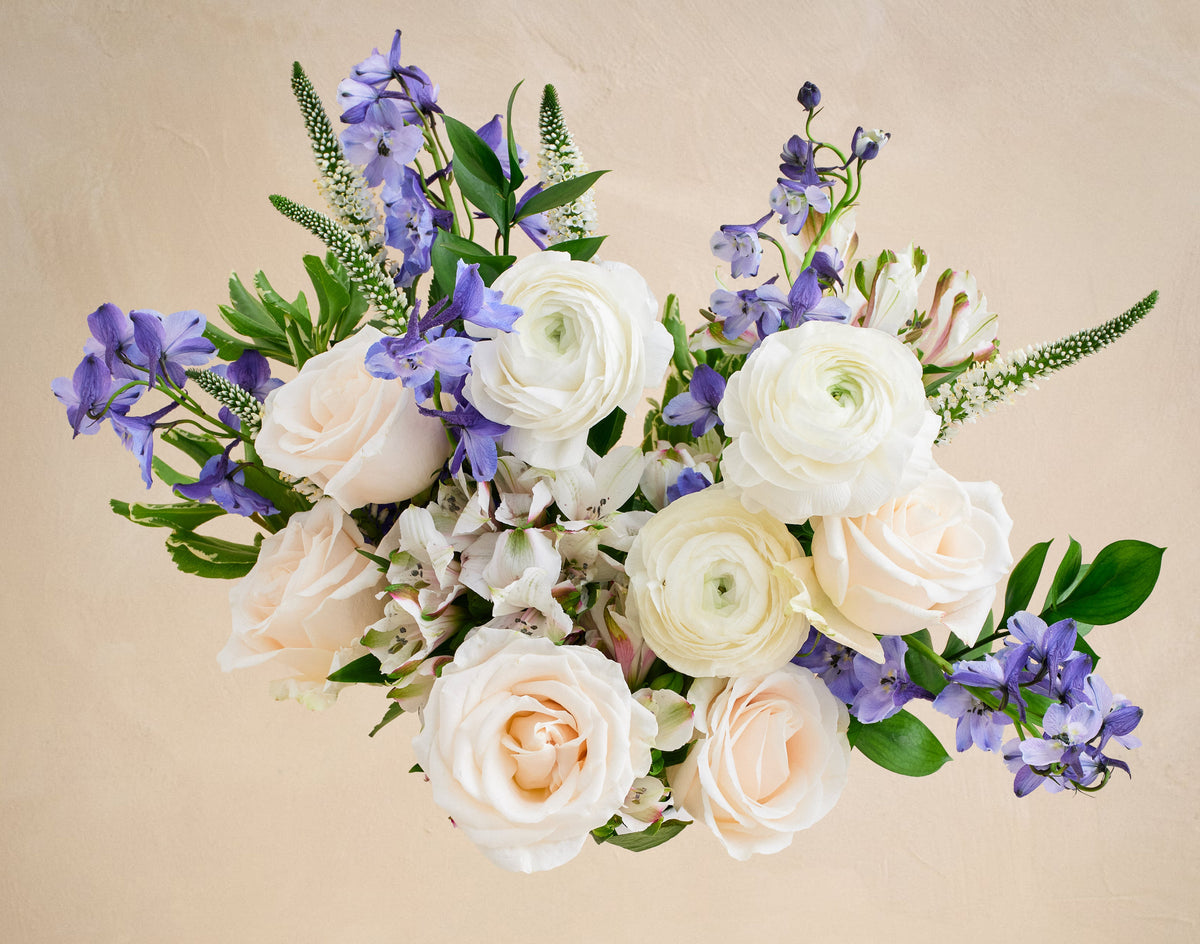 Bouquet of white and purple flowers on a beige background