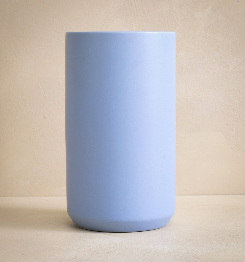 Light blue ceramic vase on a beige background