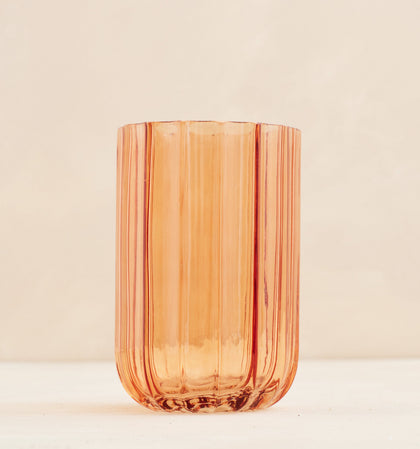 Orange glass vase on a beige background
