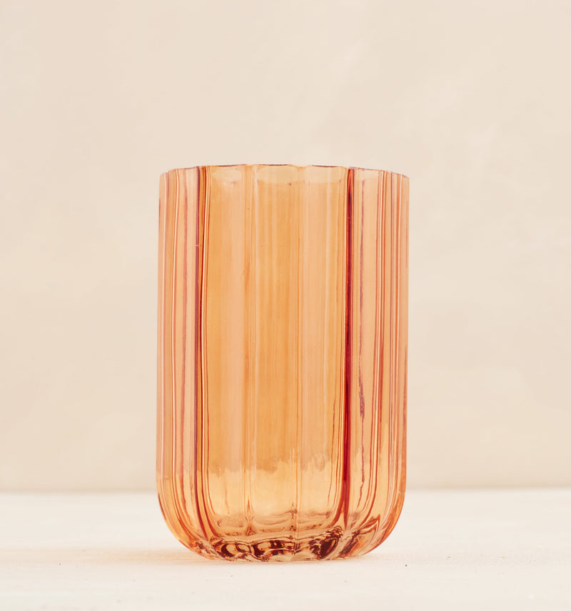 Orange glass vase on a beige background