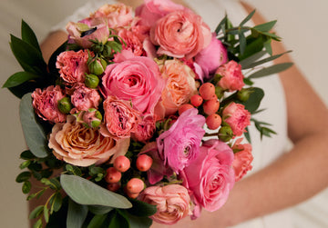 Bouquet of pink and green flowers held by a person